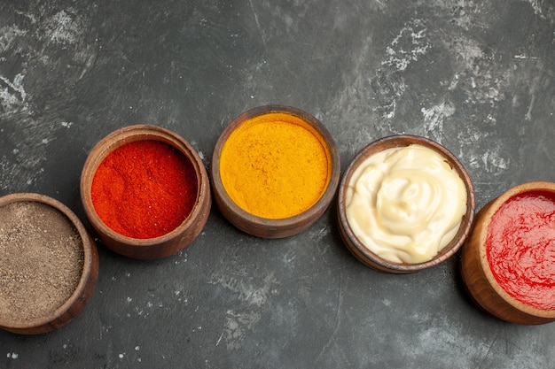 Free photo top view of set for sauces containing different spices mayonnaise and ketchup on gray background