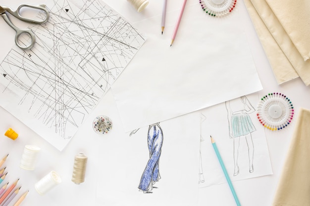 Top view of sewing essentials with textiles and drawing