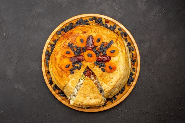 Вид сверху на вкусную рисовую муку `` шах плов '', приготовленную в круглом тесте с изюмом на темно-серой поверхности