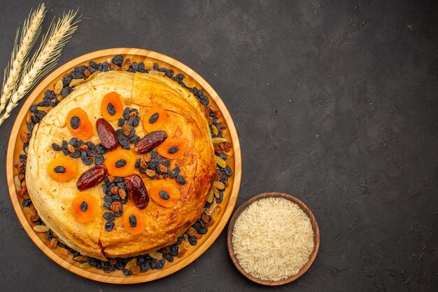 회색 표면에 건포도와 둥근 반죽 안에 요리 된 shakh plov 맛있는 쌀 식사의 상위 뷰