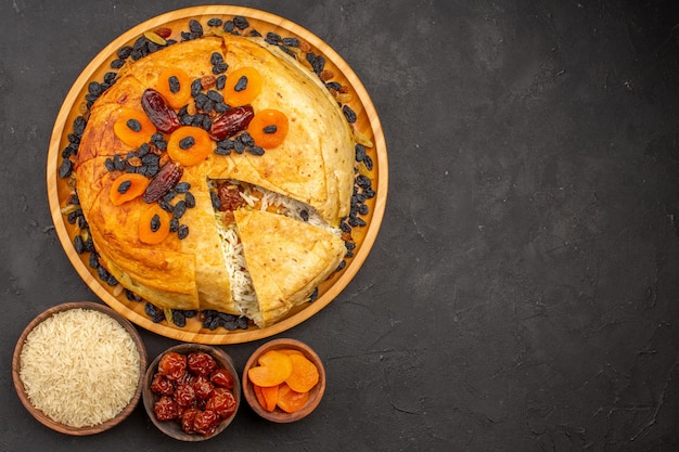 Top view of shakh plov delicious rice meal cooked inside round dough with raisins on grey surface