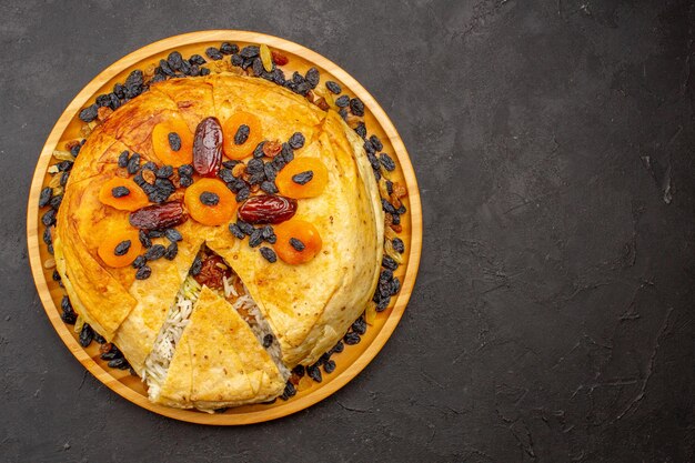 회색 표면에 건포도와 둥근 반죽 안에 요리 된 shakh plov 맛있는 쌀 식사의 상위 뷰