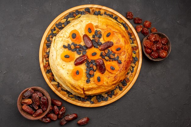 Top view of shakh plov delicious rice meal cooked inside round dough with raisins on the grey surface