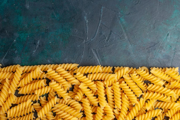 Top view shaped italian pasta on dark blue desk