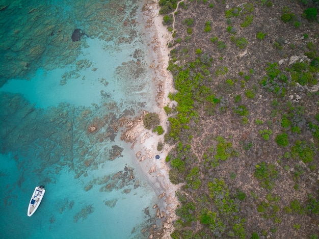 Top view shot of a boat on the blue sea near the seashore