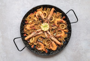 Free photo top view shot of delicious paella with seafood and onion rings