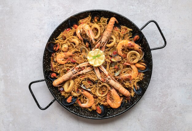 Top view shot of delicious Paella with seafood and onion rings
