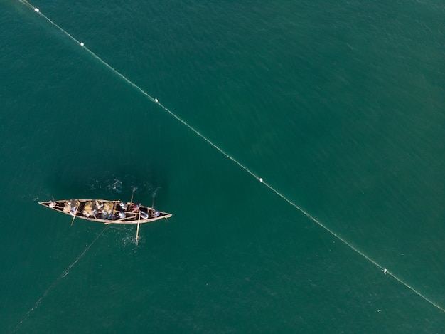 Вид сверху на людей на лодке, ловящей рыбу на пляже Варкала