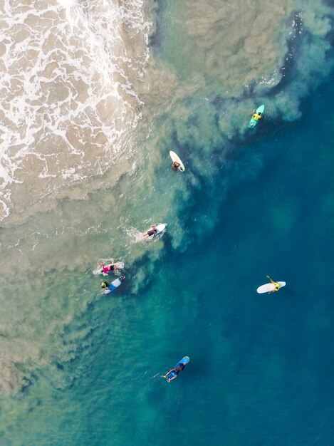 Varkala 해변에서 수영하는 서핑 보드를 가진 사람들의 상위 뷰 샷
