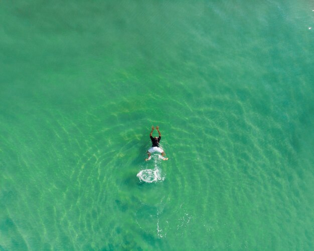 Top view shot of a person swimming in Varkala Beach