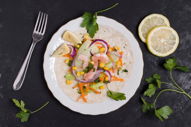 Top view of shrimp and other food on pita