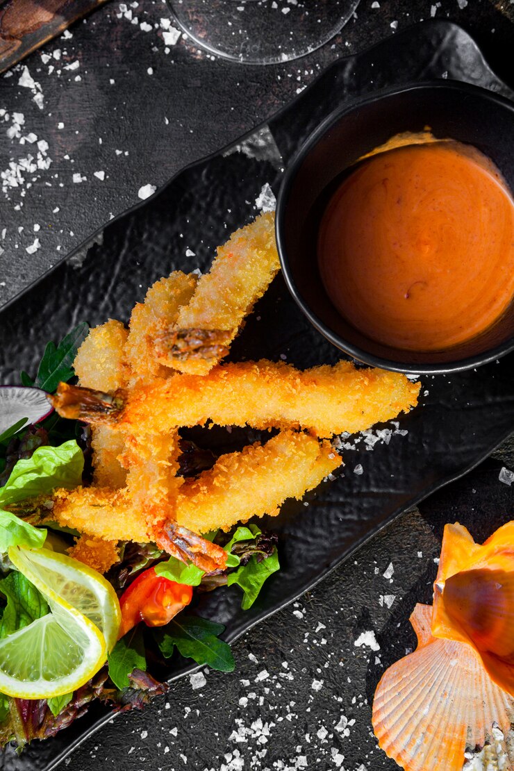 Free Photo top view shrimps in batter with sauce and fresh vegetable salad and shells in tray