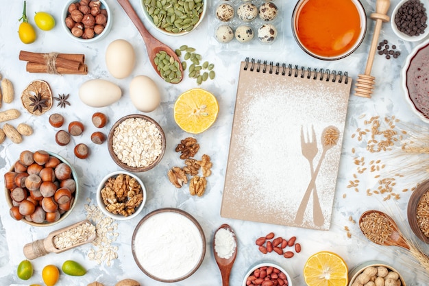 Foto gratuita vista dall'alto semplice blocco note con gelatina di farina di uova e noci diverse su dado bianco zucchero color torta pasta dolce alla frutta