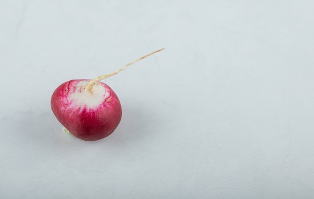 Top view of single purple radish on white background.