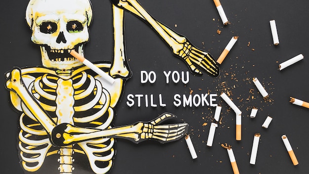 Free photo top view skeleton with cigarettes