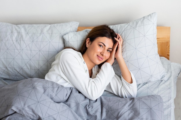 Foto gratuita vista dall'alto della donna sonnolenta a letto che indossa un pigiama