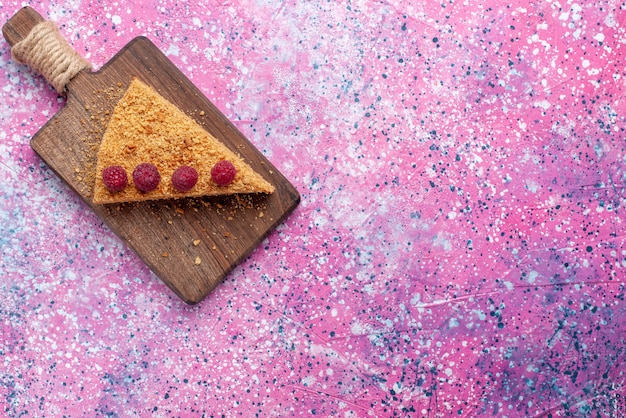 Top view slice of cake baked and sweet with raspberries on bright-pink desk bake cake pie fruit