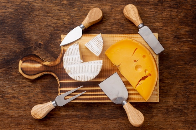 Top view slice of cheese with tools on a table