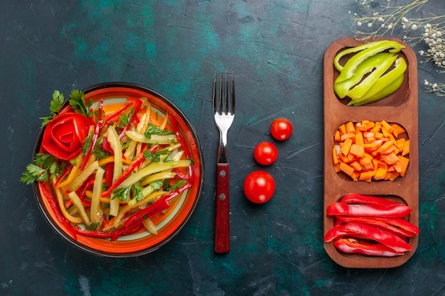 Top view sliced bell peppers different colored vegetable salad with ingredients on dark-blue background