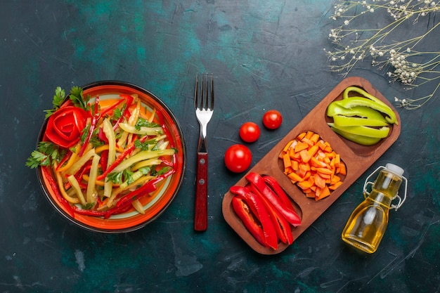 Top view sliced bell peppers different colored vegetable salad with ingredients and oil on dark-blue background