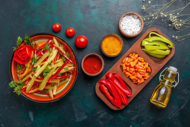 Top view sliced bell peppers different colored vegetable salad with ingredients and oil on dark blue background