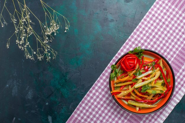 Top view sliced bell-peppers salad on dark-blue background