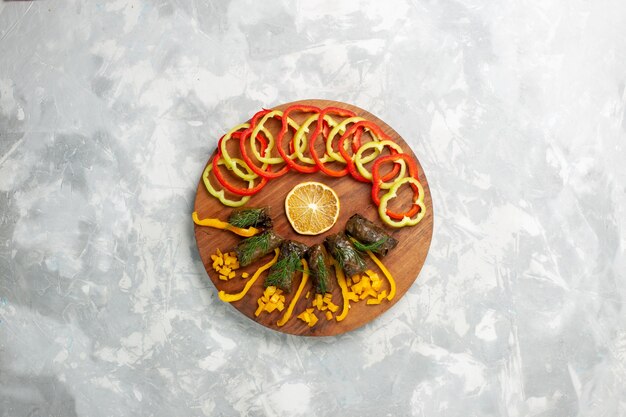 Top view sliced bell-peppers with leaf dolma on white desk