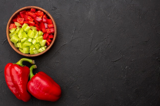 Foto gratuita vista dall'alto peperoni affettati con peperone rosso su sfondo grigio piccante cibo pasto caldo