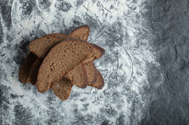밀가루 배경에 슬라이스 브라운 빵의 최고 볼 수 있습니다.