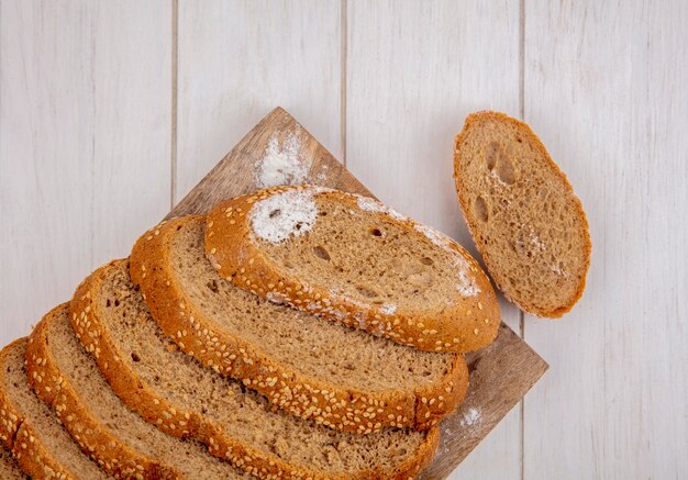 Top view of sliced brown seeded cob on cutting board and on wooden background