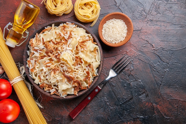 Vista dall'alto a fette di pasta cotta con riso sulla superficie scura pasta scura piatto