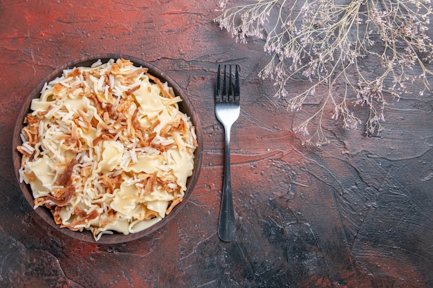 어두운 표면 식사 파스타 접시 반죽에 쌀과 함께 요리 된 반죽을 슬라이스 상위 뷰