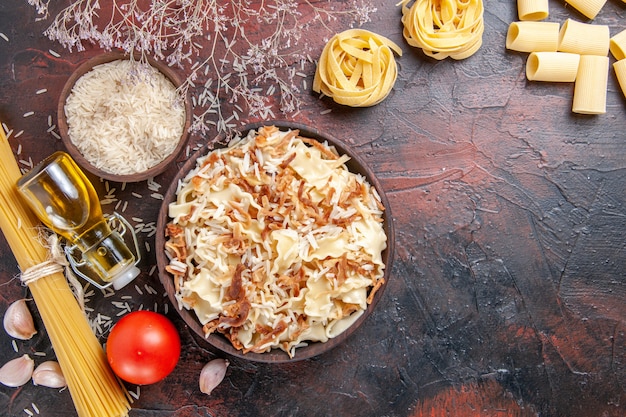 Foto gratuita vista dall'alto a fette di pasta cotta con riso sulla superficie scura pasta piatto pasta scura