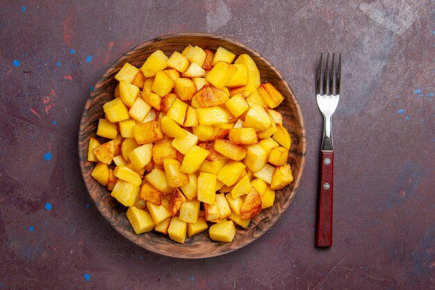 Top view sliced cooked potatoes inside plate on dark