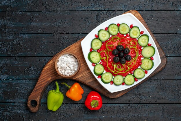 Top view sliced cucumbers with olives inside plate on dark rustic desk diet salad vegetable vitamine health