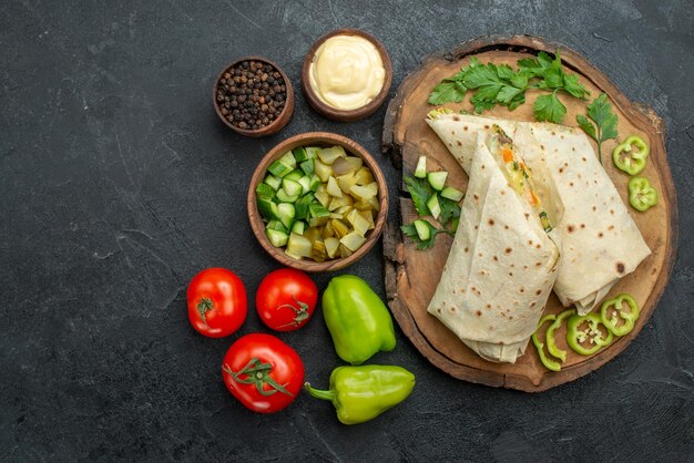 上面図スライスしたおいしいシャワルマサラダサンドイッチと新鮮な野菜の灰色の表面の食事ピタサラダサンドイッチバーガー