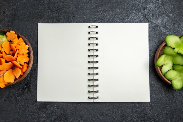 灰色の背景にメモ帳付きの上面スライスデザインサラダサラダ健康食品ダイエット野菜