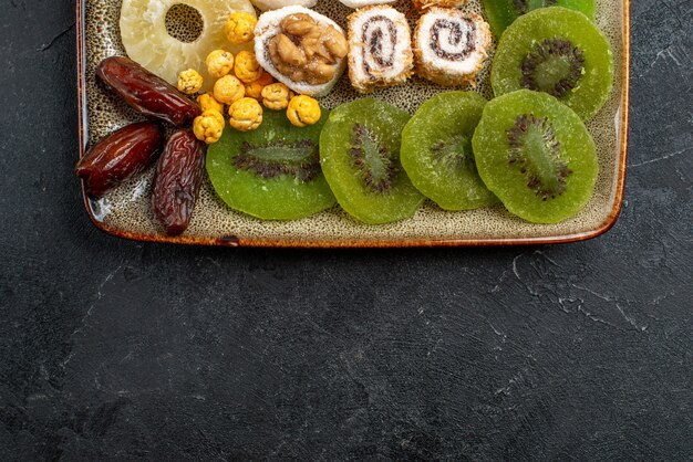 Вид сверху нарезанные сухофрукты кольца ананаса и киви на сером фоне сухофрукты изюм кисло-сладкий витамин здоровье
