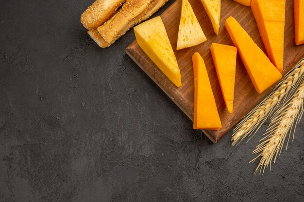 Top view sliced fresh cheese with buns on the dark background