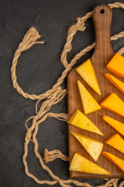 Top view sliced fresh cheese with ropes on dark background