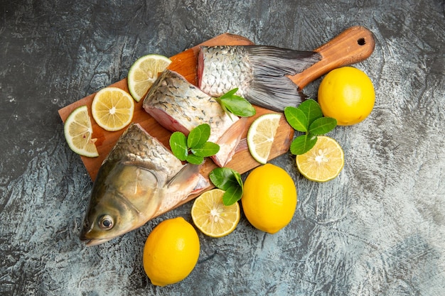 Вид сверху нарезанной свежей рыбы с лимоном на светлой поверхности