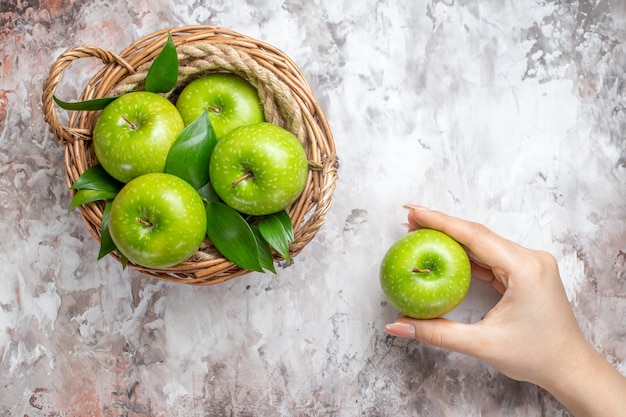 Top view sliced green apples inside basket on light background