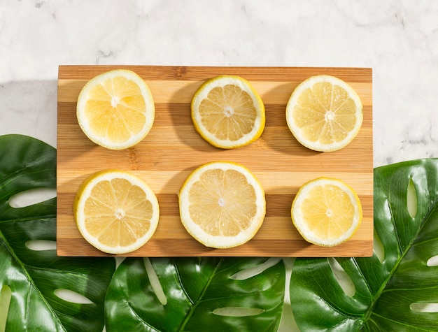 Top view sliced lemons on wooden board