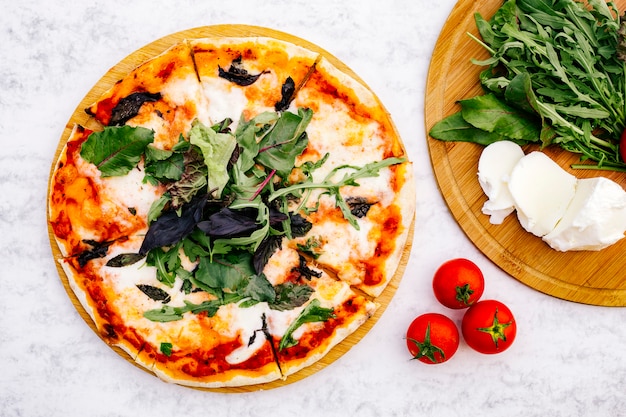 Top view of sliced margherita pizza topped with rocket