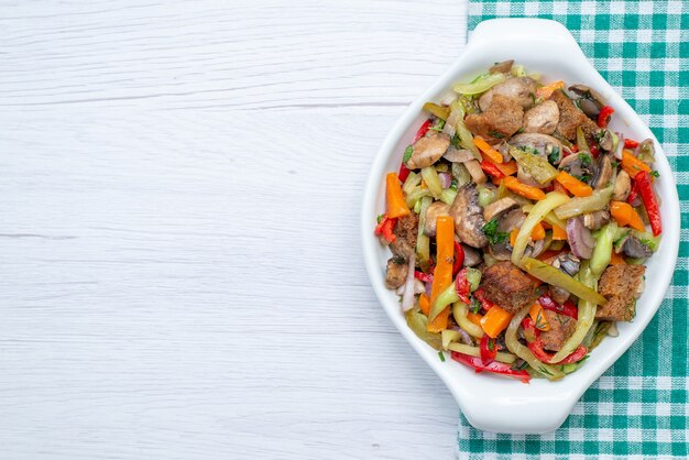 Top view sliced meat dish with cooked vegetables inside plate on the light background food meal vegetable meat