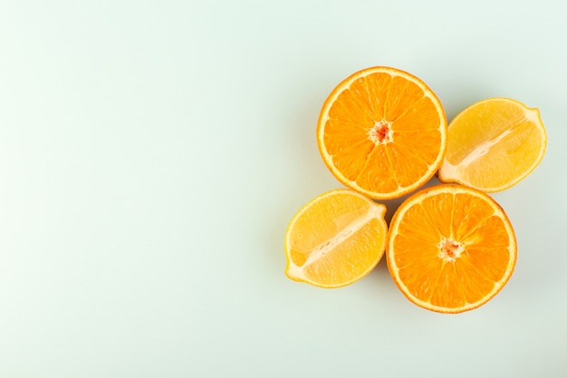 A top view sliced orange fresh ripe juicy mellow isolated half cut pieces along with sliced lemons on the white background fruit color citrus