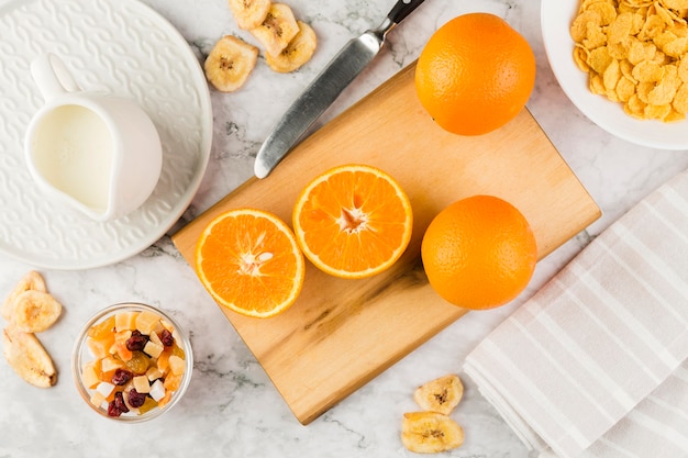 Вид сверху нарезанный апельсин с йогуртом и кукурузными хлопьями