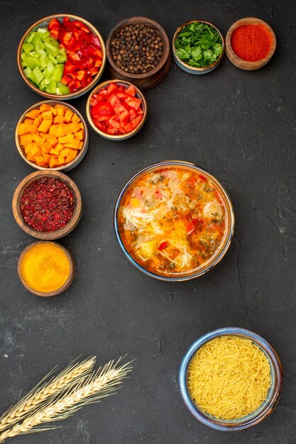 Вид сверху нарезанный перец с разными приправами и суп на сером фоне, салат, здоровая овощная острая еда