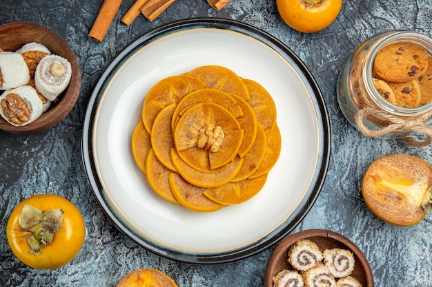 Top view of sliced persimmon on pancake on a light surface