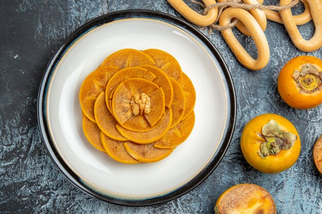 Top view of sliced persimmon on pancake on light surface